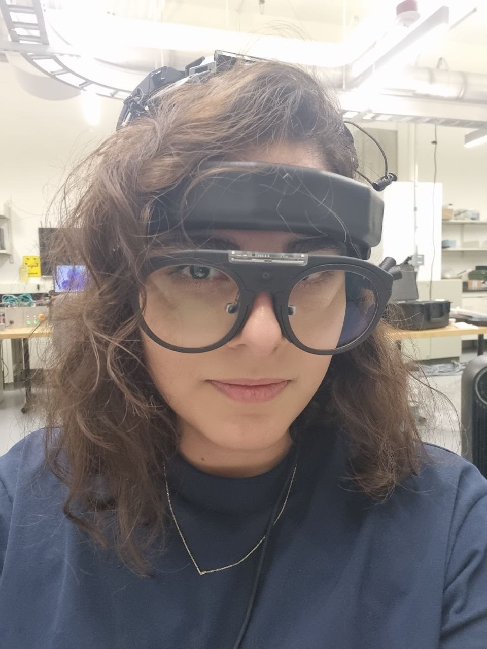 Atoosa in the lab, wearing research headgear and glasses