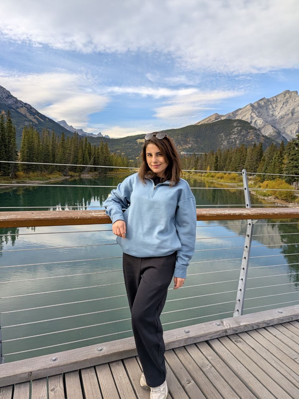 Atoosa standing on a footbridge above a river in the Canadian Rockies